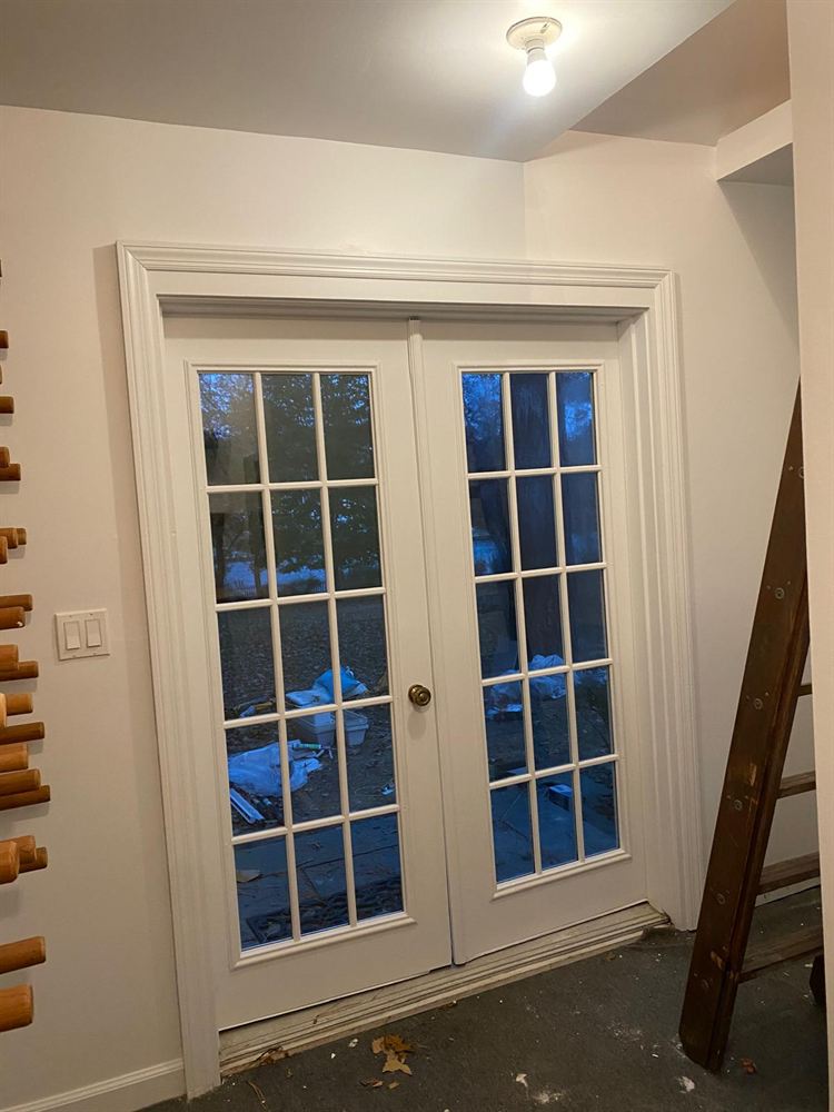 Freshly painted walls and trim around French doors in a pool house