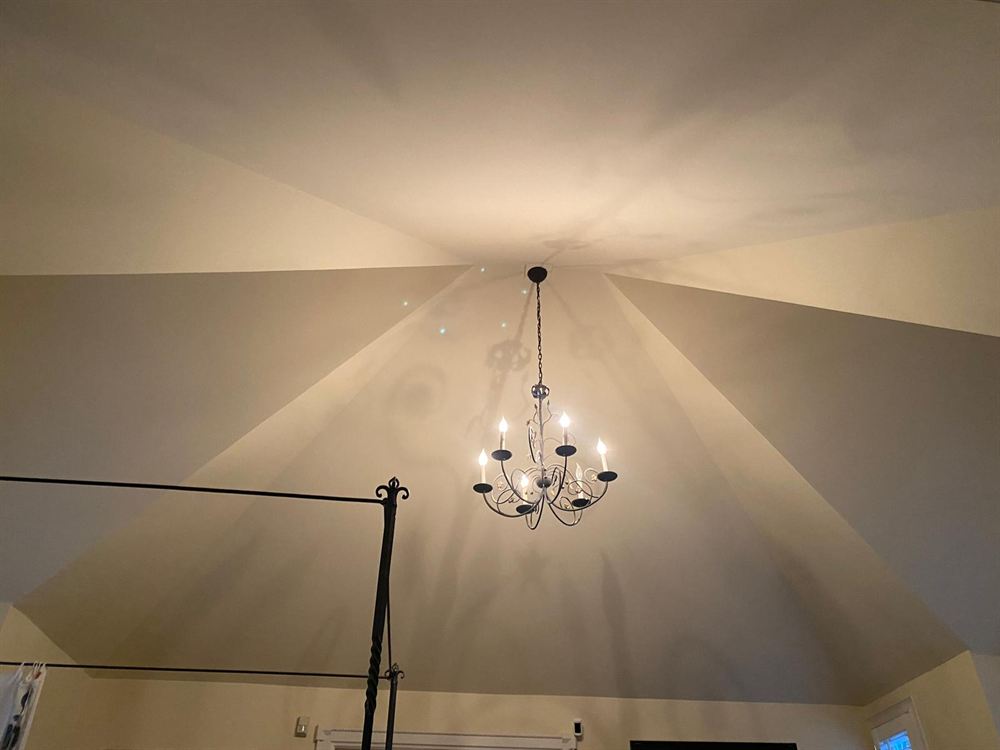 Evenly painted vaulted ceiling with a wrought iron chandelier